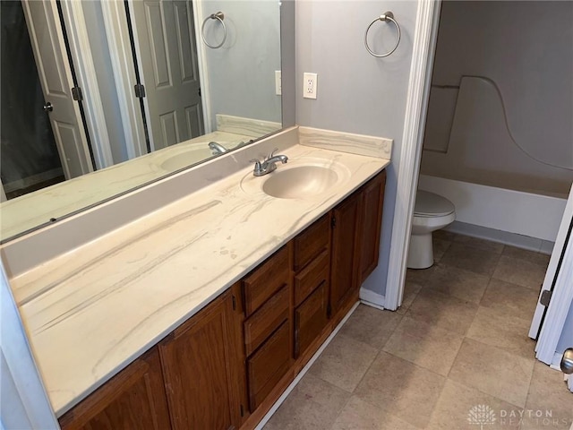 bathroom featuring vanity, toilet, and baseboards