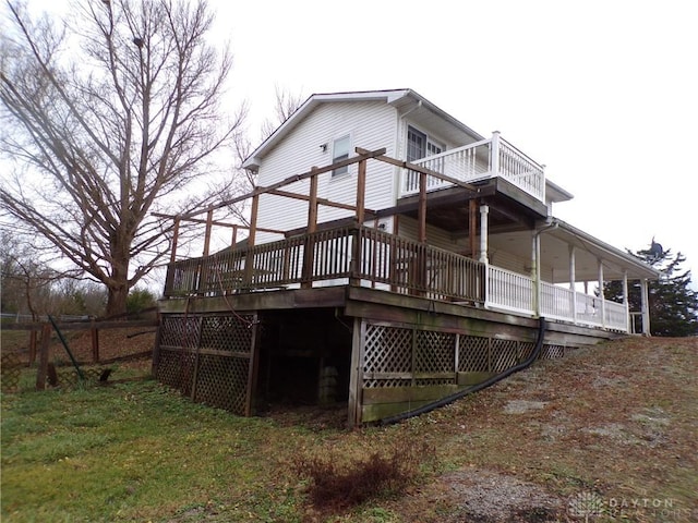 back of house featuring a deck and a lawn