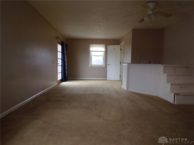 carpeted spare room featuring ceiling fan