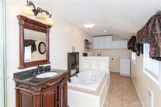 bathroom featuring a tub to relax in, tile patterned floors, a textured ceiling, vanity, and lofted ceiling