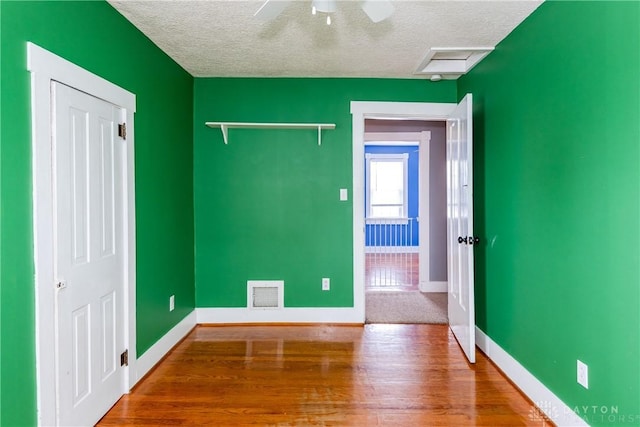 spare room with hardwood / wood-style flooring, a textured ceiling, and ceiling fan