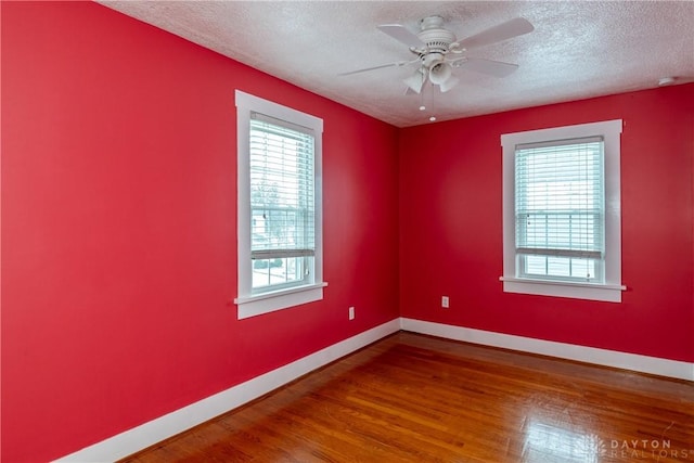 empty room featuring hardwood / wood-style floors, a textured ceiling, a wealth of natural light, and ceiling fan