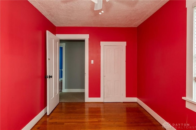 unfurnished bedroom featuring hardwood / wood-style floors, a textured ceiling, and ceiling fan