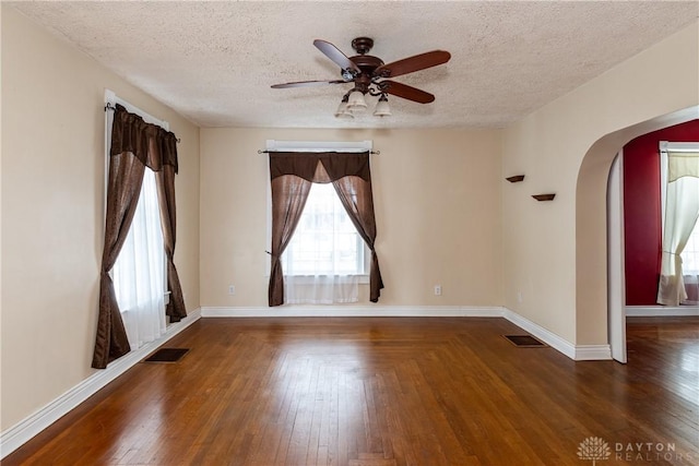 unfurnished room featuring a textured ceiling, ceiling fan, and dark hardwood / wood-style flooring