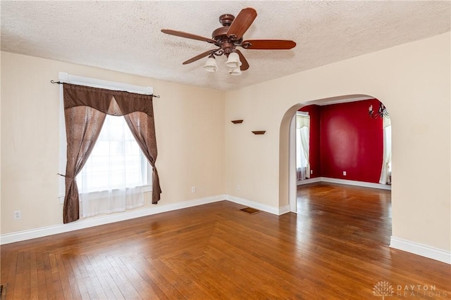 empty room featuring a textured ceiling, dark hardwood / wood-style floors, and ceiling fan