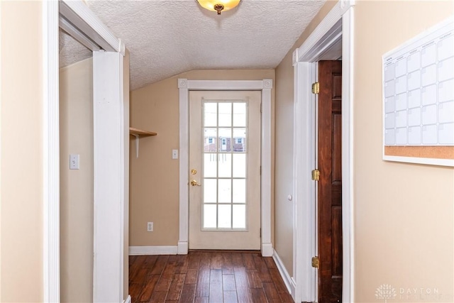 doorway featuring vaulted ceiling, a textured ceiling, and dark hardwood / wood-style flooring