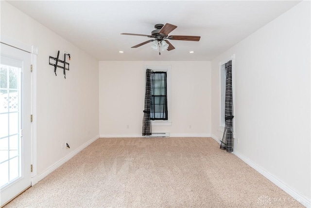 carpeted empty room featuring ceiling fan and a wealth of natural light