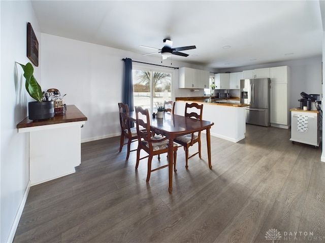 dining area with ceiling fan and dark hardwood / wood-style flooring