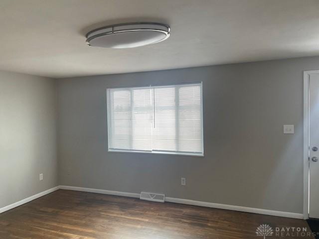 unfurnished room with dark hardwood / wood-style flooring