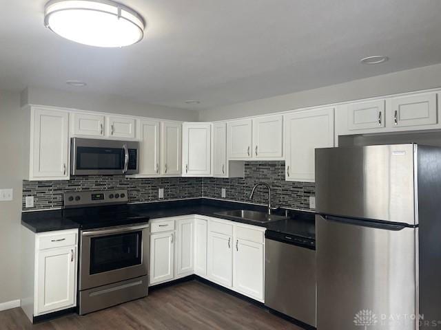 kitchen with sink, white cabinets, appliances with stainless steel finishes, and dark hardwood / wood-style flooring