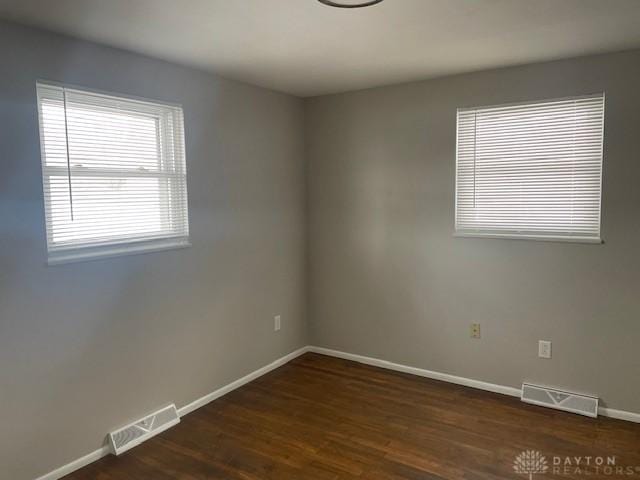 empty room with dark hardwood / wood-style flooring