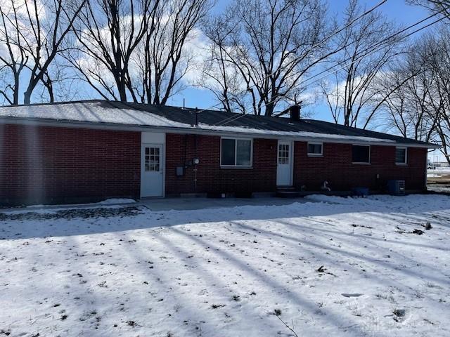 view of snow covered rear of property