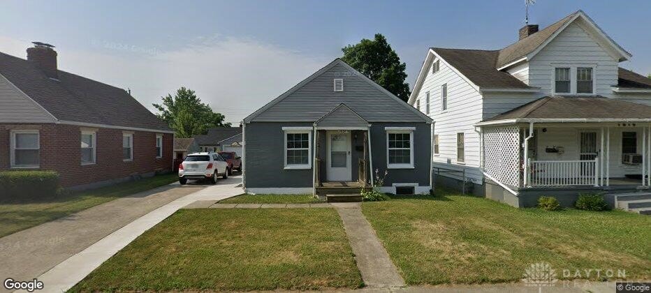 bungalow-style home with covered porch and a front yard