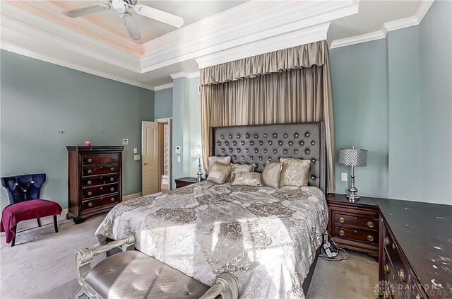 carpeted bedroom with ceiling fan, ornamental molding, and a tray ceiling