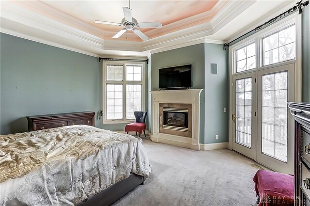 bedroom featuring crown molding, light carpet, a tray ceiling, ceiling fan, and access to exterior