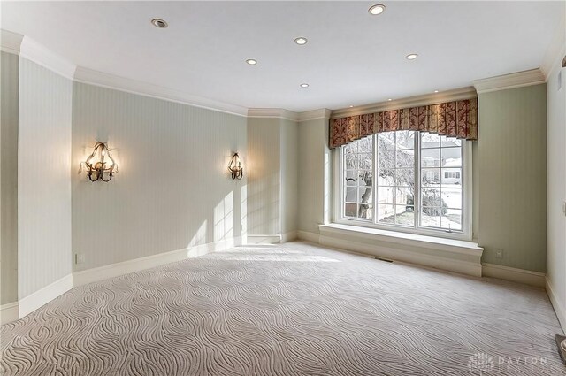 carpeted spare room featuring crown molding