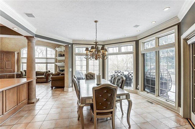 tiled dining area with ornamental molding, decorative columns, and a notable chandelier