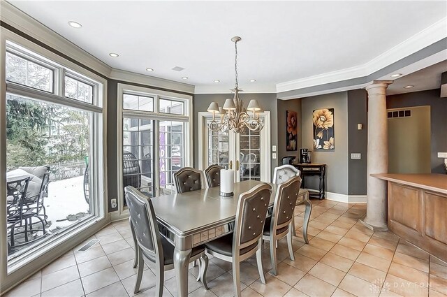 dining room featuring ornate columns, crown molding, light tile patterned floors, and a notable chandelier