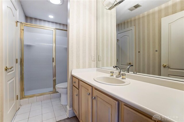 bathroom featuring vanity, tile patterned flooring, a shower with shower door, and toilet