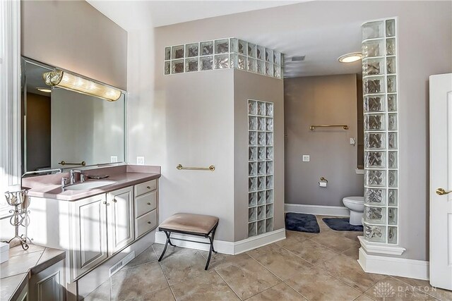 bathroom featuring tile patterned flooring, vanity, and toilet