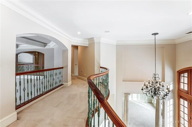 corridor with light carpet, a notable chandelier, and ornamental molding