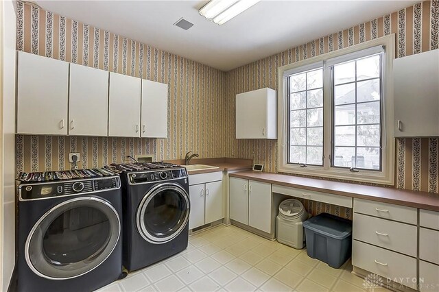 laundry area featuring cabinets, sink, and washer and dryer