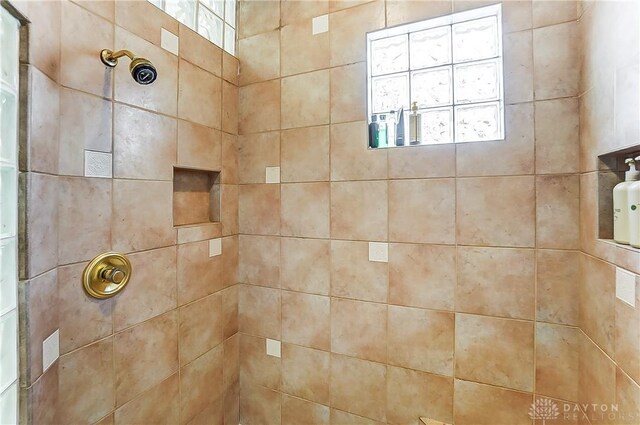 interior details featuring a tile shower