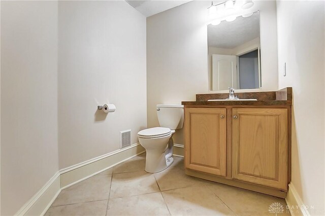 bathroom with vanity, tile patterned floors, and toilet