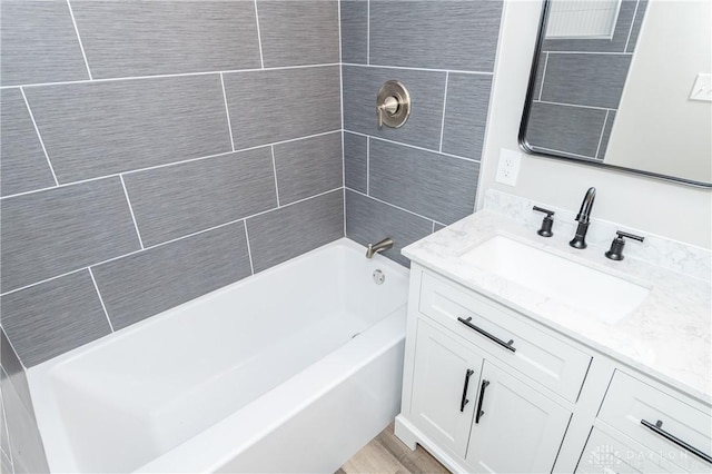 bathroom featuring vanity and tiled shower / bath