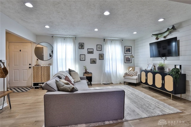 living room featuring light hardwood / wood-style flooring and a textured ceiling