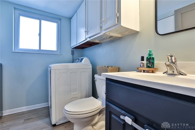 bathroom with vanity, toilet, hardwood / wood-style floors, and washer / clothes dryer