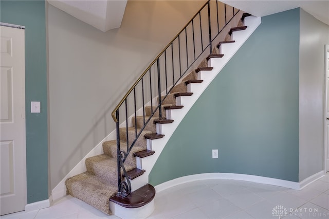 staircase featuring tile patterned flooring