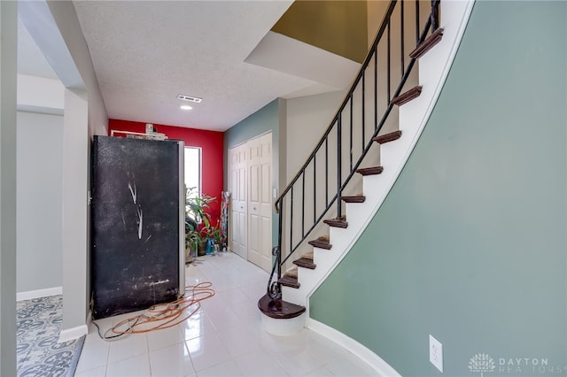 tiled entryway with a textured ceiling