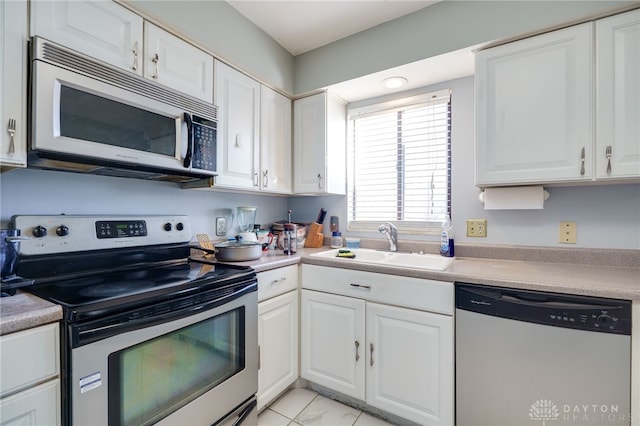 kitchen featuring light tile patterned floors, sink, white cabinetry, and appliances with stainless steel finishes