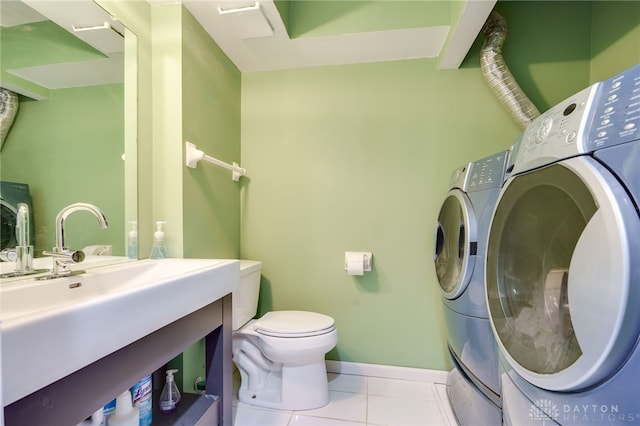 laundry area with sink, washer and clothes dryer, and light tile patterned flooring