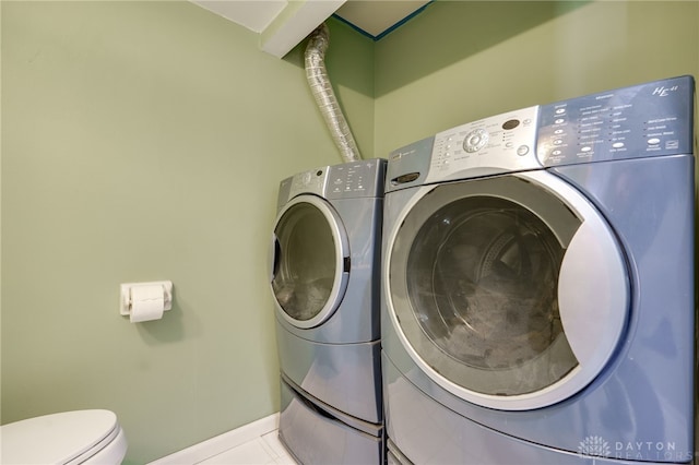 laundry room featuring tile patterned flooring and washing machine and clothes dryer