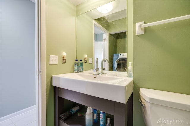 bathroom featuring washer / clothes dryer, toilet, tile patterned flooring, and vanity