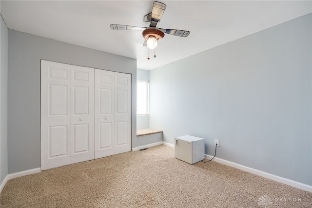 unfurnished bedroom with ceiling fan, a closet, and carpet floors