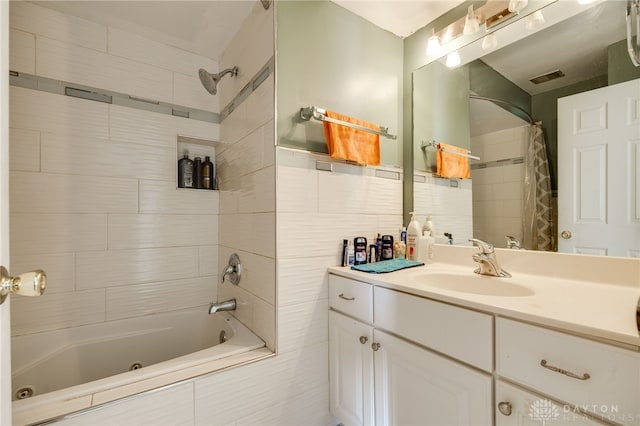 bathroom featuring vanity, tile walls, and shower / bath combo