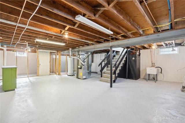 basement with a healthy amount of sunlight, sink, heating unit, and gas water heater