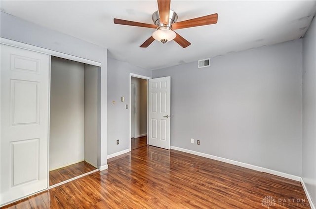 unfurnished bedroom with hardwood / wood-style flooring, a closet, and ceiling fan