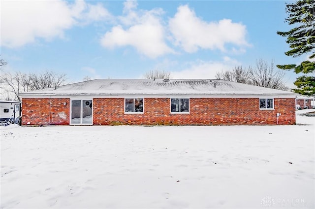 view of snow covered rear of property