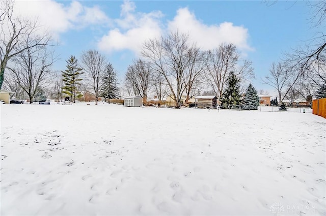 yard covered in snow with a storage unit