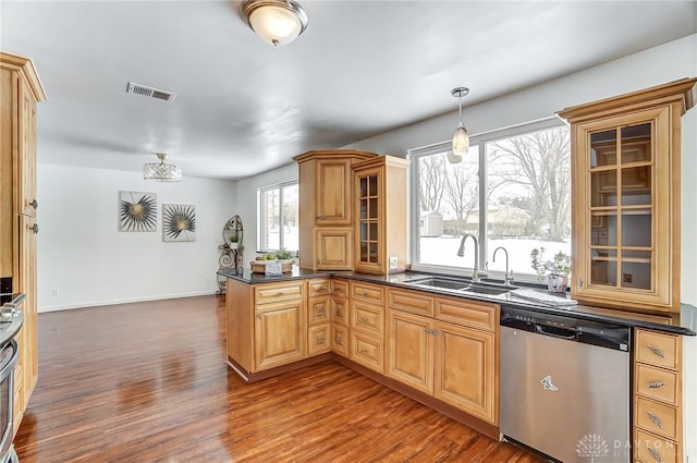 kitchen with pendant lighting, wood-type flooring, sink, kitchen peninsula, and stainless steel dishwasher