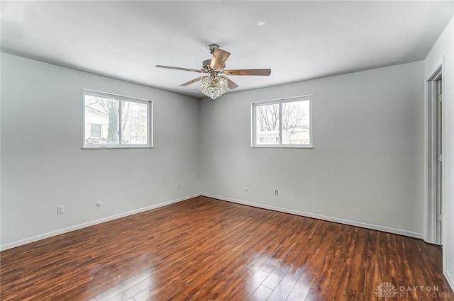 spare room featuring ceiling fan, dark hardwood / wood-style flooring, and a healthy amount of sunlight