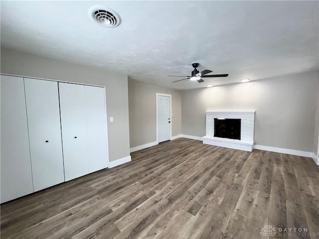 unfurnished living room with ceiling fan, wood-type flooring, and a fireplace