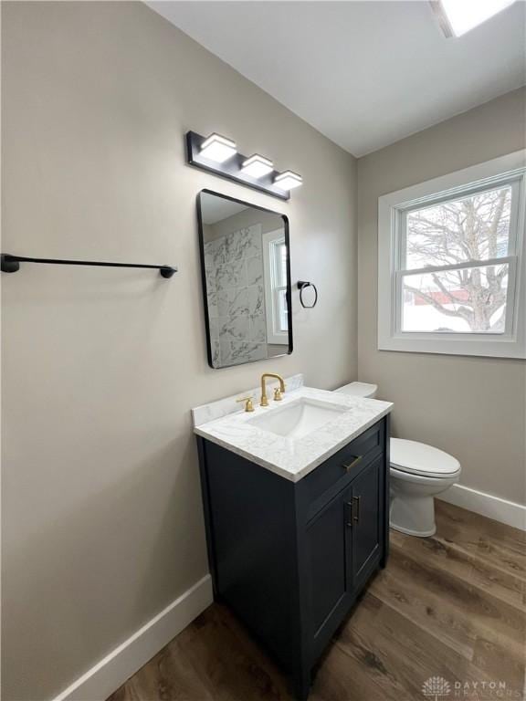 bathroom featuring wood-type flooring, toilet, and vanity