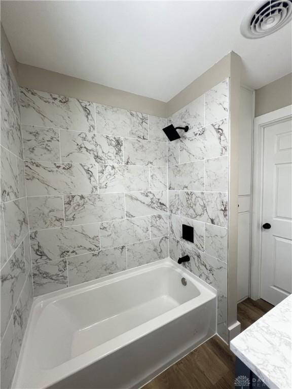 full bathroom featuring wood finished floors, visible vents, shower / bath combination, and vanity