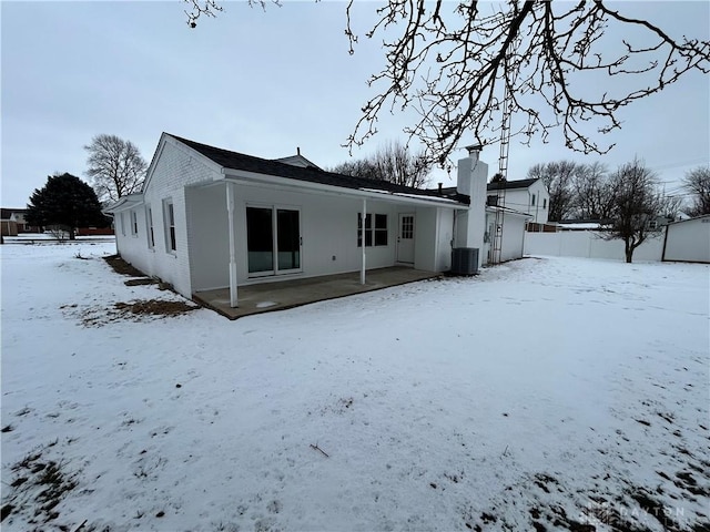 snow covered property with central AC