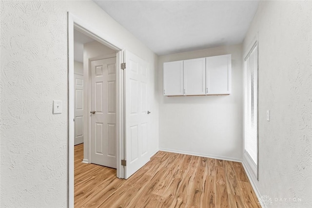 hallway with light hardwood / wood-style floors